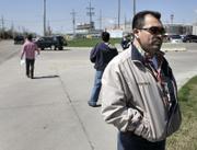 Martin Rosas, secretary-treasurer for United Food and Commercial Workers union, talks with a reporter while members of the UFCW union hand out fliers this month outside National Beef in Dodge City. Illegal immigrants are preparing for their possible arrest by saving money to pay for bail and bonds and drawing up documents for the care of their children.