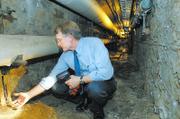 Jim Modig, Kansas University director of design and construction management, displays a handful of crumbling concrete and rusted steel in the underground tunnels below the university's power plant during a tour in September 2006. Modig said the repair to the tunnels was the highest priority for the university, with an estimated price tag of $8 million.