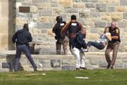 An injured woman is carried out of Norris Hall at Virginia Tech in Blacksburg, Va. A gunman opened fire in a dorm and classroom Monday at Virginia Tech on Monday, killing 32 people before he apparently killed himself, police said.