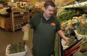 Erick Cofer, a produce employee, changes the water for the asparagus at Checkers Foods, 2300 La., on Saturday morning. Many farmers lost their asparagus during the recent freeze, causing higher prices for grocery stores and their customers.
