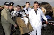 The Russian Space Agency search-and-rescue team officers carry U.S. Space tourist Charles Simonyi shortly after his landing Saturday in Russian Souyz TMA-9 space capsule about 500 km (310 miles) southwest of the Kazakh town of Karaganda. A Russian cosmonaut and an American astronaut returned to Earth along with a U.S. billionaire whose paid voyage to the international space station ended with a landing on the Kazakh steppe.