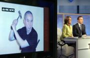 NBC "Today" television show co-hosts Meredith Vieira and Matt Lauer report Thursday in New York on a video manifesto and photos sent to their network by Virginia Tech gunman Seung-Hui Cho, shown on a studio monitor at left brandishing a hammer.