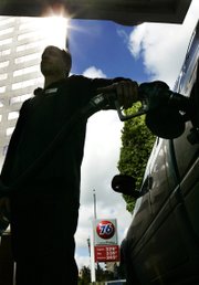 Gas prices loom on a marquis as attendant Shawn Calhoun pumps gas Monday in downtown Portland, Ore. Gasoline prices have gone up more than 8 cents across the country the last two weeks and are up 69 cents so far this year, according to the latest Lundberg Survey released Sunday.