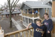 Joey Minder, 7, and his sister Sophia, 9, stand on the balcony of a house in the Delaware Street Commons in the 1200 block of Delaware. The Commons, which will be on the Spring Parade of Homes, is the only co-housing community of its kind in the region. In the background from left are Commons residents, from left, Vicki Penner, Linda Peckham, Jennifer Distlehorst and Penner's husband, Rich Minder. The neighborhood includes 21 energy-efficient condo-style homes and a communal house, pictured at lower left.