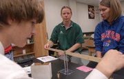 John Olson, Free State High School physics teacher, center, works Thursday with Free State sophomore Eric Gruber, left, and senior Alex Chamberlain. Olson will receive a Wolfe Teaching Excellence Award from Kansas University.