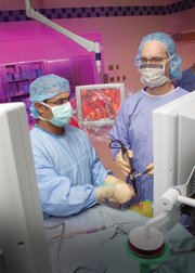 Dr. Carl Snyderman, right, uses an endoscope to view a patient's brain while Dr. Amin Kassam removes a brain tumor through the nose using special instruments designed for the surgery. The procedure was done in September 2006 at the University of Pittsburgh Medical Center.