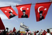 Pro-secular demonstrators walk beneath Turkish flags carrying portraits of Turkey's founder Ataturk during a rally Sunday in Istanbul, Turkey. Hundreds of thousands of pro-secular Turks flooded central Istanbul to demand the resignation of the government, which they fear is leading Turkey toward Islamic rule.