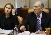 Israeli Foreign Minister Tzipi Livni, left, and Prime Minister Ehud Olmert attend a special meeting of the cabinet in Jerusalem. Livni on Wednesday called on Olmert to resign and said she would challenge him for leadership of the ruling Kadima Party. After the meeting, Olmert remained in control after having secured the backing of a majority of party members.