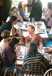 Teller's Server Dannielle Wilson chats with customer Sherie Surbaugh, Leawood, during lunch rush at the downtown Lawrence restaurant last month. Restaurant staffs will be busy May 13 with Mother's Day customers.