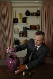 Rumsey-Yost Funeral Home Director Bart Yost displays one of dozens of urns available to house cremated remains on Wednesday at the funeral home located at 601 Indiana.