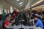 Kansas University students pack into a computer work room in Anschutz Library. Like textbooks, personal computers have become a staple academic item at universities across the country.