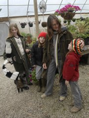 Home schooling for the Davison sisters sometimes means working together as a family in their parents' business, Vinland Valley Nursery. From left in the greenhouse are Emma Davison, 11, Celie Davison, 10, their mother Amy Albright and Bess Davison, 6.