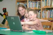 Sarah Kouns, at left, works with her 5-year-old son Jacob on his studies at the Tonganoxie Public Library. Also looking on his Jacob's younger sister, Hannah, who is 3. Sarah and Jason Kouns, of Tonganoxie, school Jacob at home.