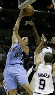 Utah's Deron Williams (8) goes up for a shot against San Antonio's Tony Parker (9) and Michael Finley. The Spurs defeated the Jazz, 105-96, on Tuesday night in San Antonio.