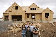 The Astle family, children Kayla, Mason and Ali, and parents Valerie and Evan, pose outside their new 5,700-square-foot home Tuesday in Kaysville, Utah. The state has the biggest concentration of big homes in the nation. Ali, 15, hates the idea of moving from the family's current 2,074-square-foot home. She'll be leaving her friends and attending her arch-rival high school in the fall.