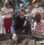 Roger Doiron of Scarborough, Maine, assists students at Pleasant Hill Elementary School in Scarborough with their garden. Doiron started a Web site called Kitchen Gardeners International, which promotes taking control of the food you eat and reducing the distance it travels by growing your own food in your backyard.