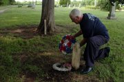 Bob Wandel, a member of Sons of Union Veterans, places a wreath near the tombstone of Anna Jessie, who died at age 5 in 1878, at Clinton Cemetery.