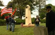 Members of the Sons of Union Veterans of the Civil War gather Monday afternoon at Pioneer Cemetery on Kansas University's West Campus to rededicate a monument to unknown Union soldiers killed in the Civil War, while Bob Wandel reads some history about the monument.