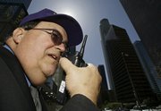 Private security guard Richard Bergendahl talks on his radio in downtown Los Angeles. The 72-story U.S. Bank Tower, formerly known as Library Tower, seen in the background, is the tallest office building on the West Coast and is just down the street from the high rise where Bergendahl works.