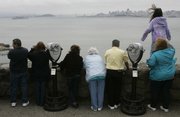 Spectators scan the water at a vista point near Sausalito, Calif., looking south toward San Francisco. Two lost whales last spotted near the Golden Gate Bridge may have slipped back into the Pacific Ocean after a two-week sojourn that took them 90 miles inland up the Sacramento River, scientists said Wednesday.