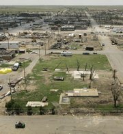 An aid worker patrols the nearly empty streets Monday in Greensburg. Cleanup and rebuilding continues in the community of 1,400, which was ravaged one year ago by an F-5 tornado.