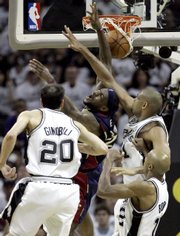 Cleveland star LeBron James, center, runs into a trio of Spurs - Manu Ginobili (2), Tim Duncan, top right, and Bruce Bowen - in the first half of the Spurs' 85-76 victory. James had a subpar 14 points in the setback Thursday in San Antonio.
