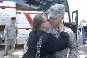 Susan Rozell greets her son Tim Rozell, both of Topeka, with a big kiss as he gets off a charter bus. Members of the 130th Field Artillery National Guard out of Topeka arrived from Iraq on Saturday.