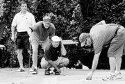 From left, Calvin Heck, Charlie Becker and Ron Miller help line up a putt for James Hicks on hole 11 at Alvamar Country Club. Golfers must navigate sand, trees and rough surrounding the green on No. 11, one of the toughest holes in Lawrence. The foursome played in the Lawrence Memorial Hospital Endowment's Penny Jones Golf Tournament last summer.