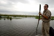 A man pushes his boat in the Esteros del Ibera, north of Argentina, near the area owned by U.S. businessman Douglas Tompkins. Tompkins now owns well more than 1 million acres in Chile and Argentina, a combined area larger than Belgium that he says he wants to save from agribusiness and development.