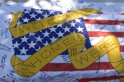 A banner signed by onlookers was presented to the troops in the 130th Field Artillery Brigade National Guard that arrived Saturday at Hayden High School in Topeka.