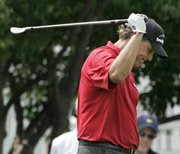 Phil Mickelson swings his club over his head after teeing off on the 17th hole during the first round of the U.S. Open. Mickelson shot a 4-over 74 Thursday at Oakmont Country Club.