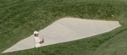 Aaron Baddeley chips out of a bunker on the 17th hole. Baddeley leads Tiger Woods by two strokes after the third round of the U.S. Open on Saturday in Oakmont, Pa.