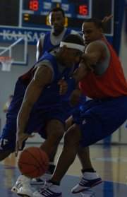 Kansas junior guard Mario Chalmers, left, dribbles around former Jayhawk Michael Lee during a scrimmage at the Bill Self Basketball Camp. Current and ex-Jayhawks scrimmaged Wednesday at Horejsi Center.