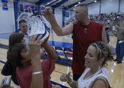 Andrew Hanzel of Lee's Summit, Mo., eyes a size-18 autographed basketball shoe from former Jayhawk and NBA basketball player Greg Ostertag, center, following a scrimmage at the Bill Self basketball camp. At right is Liz Haywood of Greenwood, Mo. Ostertag participated in a scrimmage Wednesday at Horejsi Center.