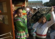 Xavier Lemus-Kenney, 11, right, adjusts his sombrero as his cousin, Jessica Lemus, center, 11, and Ashley Anguiano, left, wait for the call for dancers to take the stage for a Jalisco dance Friday during the first night of St. John's Mexican Fiesta. Festival attendees enjoyed an evening of dancing and food.