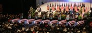 Caskets are arranged in a row during a memorial service in North Charleston, S.C., on Friday for the nine firefighters killed in a blaze in Charleston on Monday.