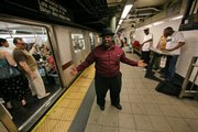 Michael Lee Anthony sings while accompanied by Alphonso McGruder, right, on keyboards and "Sugar Ray" Sanders, third from right, in performing oldies songs Tuesday as a train prepares to leave the 77th Street subway in New York. City officials say Gotham is about to get a little quieter when new noise regulations take effect July 1.