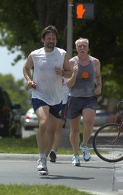 Lindy Eakin, left, vice provost for administration and finance at Kansas University, runs with members of the "KU Mad Dog Running Group" in June in downtown Lawrence. kued2007