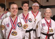 These students at the ATA Blackbelt and Leadership Academy in Lawrence were named world champions at a recent competition in Little Rock, Ark. They are, from left, Fe Brinkley, Dru Forrester, and Bill and Ginger Vermooten. Not pictured is Jimmy Golden, a 2007 sparring world champion.