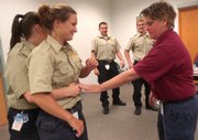 New Douglas County corrections officers, from front left, Megan Walker and Amber Davatz practice positioning for the Heimlich maneuver with sheriff's officer and instructor Deb Porter during training at the Douglas County Jail. In background at center are new corrections officers Dereck Martinez, left, and Brett Larve. The Douglas County Jail is experiencing its highest shortage of corrections officers in six years.