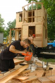 Employees of 19th Century Restoration, Jim Waddle, front, and Chris Stewart, work on the Casa4CASA playhouse, which is modeled on a fisherman's cottage. Chances to win the playhouse are sold, and the proceeds benefit the CASA program, a nonprofit agency that recruits community volunteers to advocate for abused or neglected children in the court system.