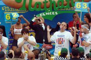 Joey Chestnut, second from right, of San Jose, Calif., throws his hands up at the end of Nathan's Famous July Fourth International Hot Dog Eating Contest in Brooklyn, N.Y. Chestnut beat Japan's Takeru Kobayashi, left, the six-time defending champion.