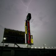 Lightning dances across the sky over the Nextel scoring tower at the Daytona International Speedway. Rain Friday forced cancellation of qualifying for tonight's Nextel Cup race and postponed the Busch Series race until this morning.