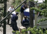 State and federal officials load coolers of evidence into a truck as they search the grounds behind a home owned by Atlanta Falcons quarterback Michael Vick. The officials were looking for evidence in a possible dog fighting investigation Friday in Smithfield, Va.