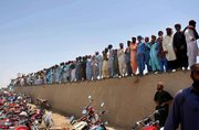 Mourners stand over a wall during the funeral ceremony of pro-Taliban Pakistani cleric Abdul Rashid Ghazi, who was killed in the siege of the Red Mosque, Thursday at his ancestral village Basti Abdullah, Pakistan. The captured chief cleric of the Red Mosque led prayers for his slain brother, and forecast that the death of the mosque&squot;s defenders would push Pakistan toward an "Islamic revolution."