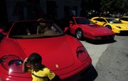 Two-year-old Cordan Vaeono inspects a Ferrari on Sunday during a car show by the Kansas City chapter of the Ferrari Club of America in downtown Lawrence. "He loves cars," his father, Tony Vaeono, said.