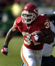 Kansas City running back Priest Holmes runs against the Philadelphia Eagles in October 2005, the last month he suited up for the Chiefs. The team announced Wednesday that Holmes would report to training camp Saturday in River Falls, Wis.