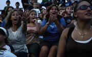 Demolition derby fans, from left, Melissa McCauley, Mary Schwartz, 10, and her mother, Linda Ransopher, all of Lawrence, get caught up in the action during the first heat of the derby Friday night at the Douglas County Fair.