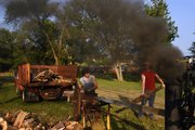 Matt Petty, left, of Meriden and Less McDonald, of Lincoln, Neb., cut firewood Saturday with Jeff Mathews, of Lecompton, not pictured, at the 50th annual Threshing Bee in McLouth. Mathews, who has been running engines at the bee for 25 years, said they were using a freelance half-scale steam engine.