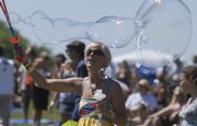 Amy Roller, of Des Moines, Iowa, releases a stream of bubbles on the lawn at the Revival Stage during the Wakarusa Music & Camping Festival in June. Bubbles last longer in humid conditions, something Kansas is rarely short on this time of year.